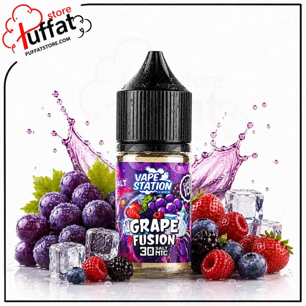 Vape Station Grape Fusion Super Ice Salt 30ml.webp shows a Vape Station Grape Fusion Super Ice SaltNic vape juice bottle surrounded by a large cluster of purple grapes with a green leaf on the left, a vibrant assortment of mixed berries (including strawberries, raspberries, blueberries, and blackberries) on the right, several clear ice cubes scattered around the base, and dynamic purple-tinted liquid splashes on a white background featuring a "Puffat Store" logo in the top-left corner.
